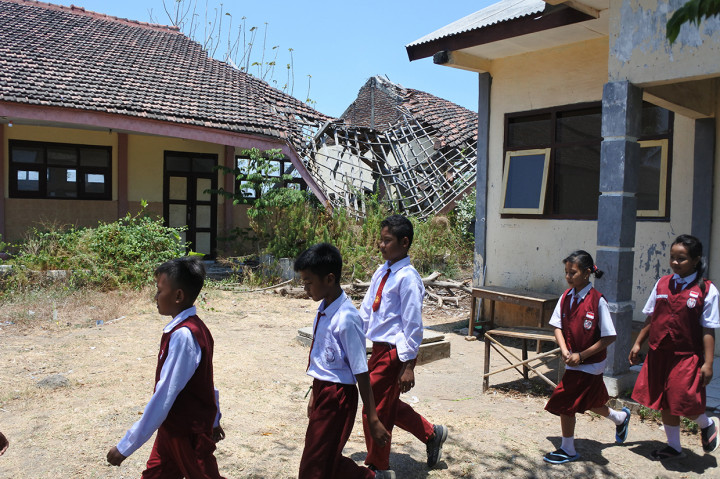 Siswa SDN 1 Sopet berjalan di depan ruang kelas yang rusak di Desa Sopet, Jangkar, Situbondo, Jawa Timur.