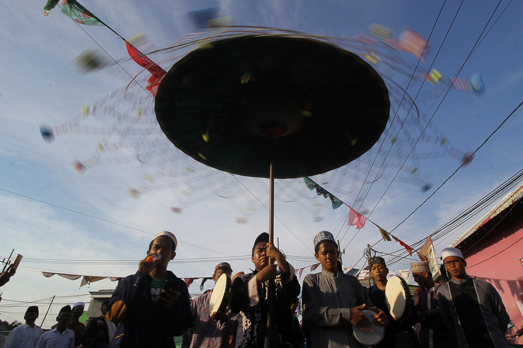 Peserta menabuh rebana dan membaca shalawat saat mengikuti pawai Maulid Nabi di Kampung Nelayan Nambangan-Cumpat, Surabaya, Jawa Timur. Antara Foto/Moch Asim