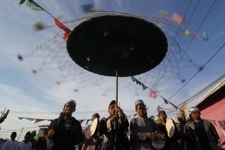 Peserta menabuh rebana dan membaca shalawat saat mengikuti pawai Maulid Nabi di Kampung Nelayan Nambangan-Cumpat, Surabaya, Jawa Timur. Antara Foto/Moch Asim