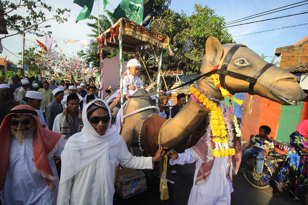 Peserta mengarak seorang murid di atas replika unta saat mengikuti pawai Maulid Nabi di Kampung Nelayan Nambangan-Cumpat, Surabaya, Jawa Timur, Jumat, 8 November 2019. Antara Foto/Moch Asim