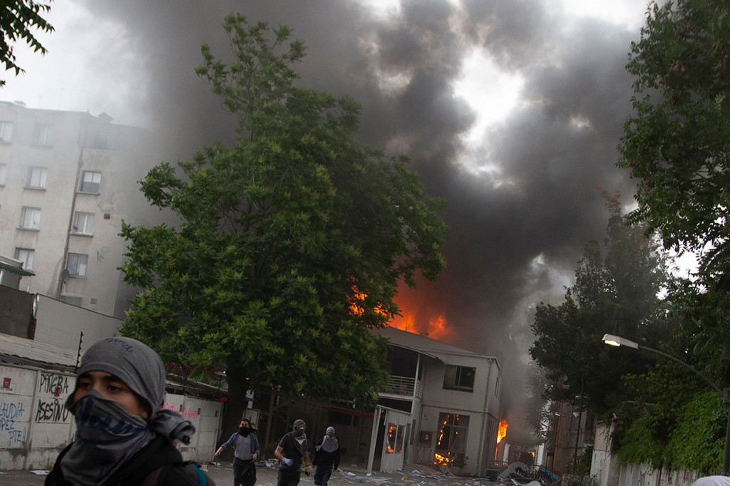 Dalam aksi yang awalnya berlangsung damai, sejumlah demonstran membakar gedung universitas Pedro de Valdivia dan menjarah sebuah gereja. AFP Photo/Claudio Reyes