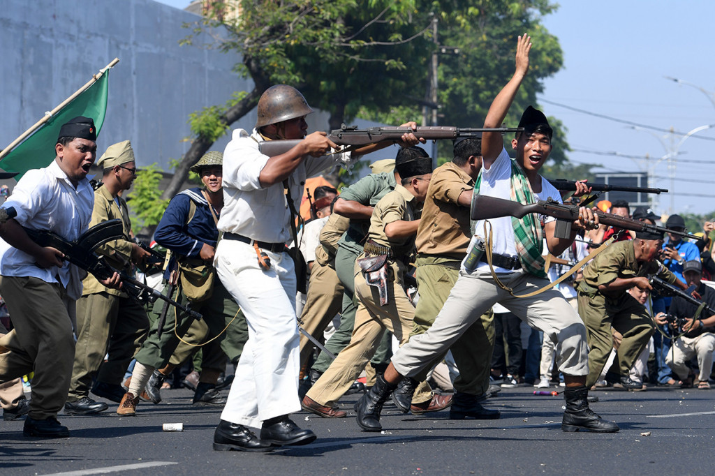 Peserta parade menampilkan aksi teatrikal pertempuran pejuang Indonesia melawan pasukan Inggris saat Parade Surabaya Juang di Jalan Tunjungan, Surabaya, Jawa Timur.