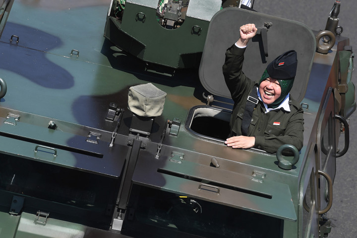 Wali Kota Surabaya Tri Rismaharini yang berada di atas kendaraan tempur menyapa warga ketika melintasi Gedung Negara Grahadi saat Parade Juang Surabaya, Surabaya, Jawa Timur.