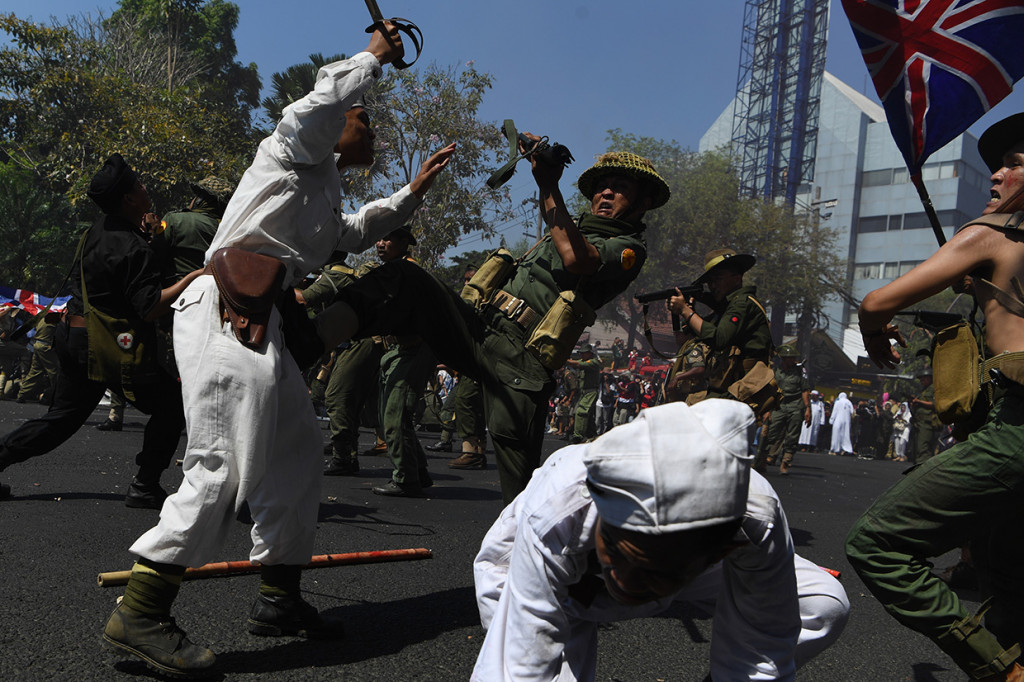 Peserta parade menampilkan aksi teatrikal pertempuran pejuang Indonesia melawan pasukan Inggris saat Parade Surabaya Juang di depan Gedung Negara Grahadi, Surabaya, Jawa Timur.