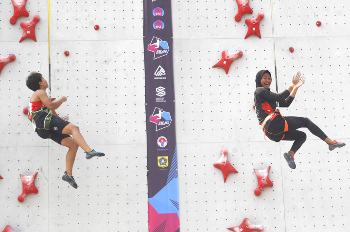 Atlet panjat tebing Indonesia Nurul Iqamah (kanan) melakukan selebrasi setelah mengalahkan atlet panjat tebing Cina Tian PeiYang (kiri) dalam babak final nomor speed putri pada kejuaraan Panjat Tebing Asian Championship 2019 di area Stadion Pakansari, Cibinong, Bogor, Jawa Barat. Antara Foto/Yulius Satria Wijaya