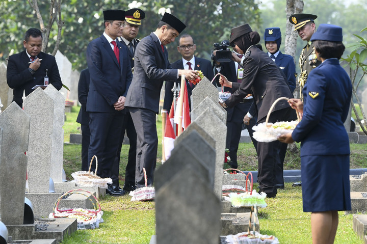 Presiden Joko Widodo (tengah) bersama Menteri Sosial Juliari Batubara (kedua kiri) melakukan tabur bunga seusai Upacara Ziarah Nasional di Taman Makam Pahlawan Nasional Utama Kalibata, Jakarta.
