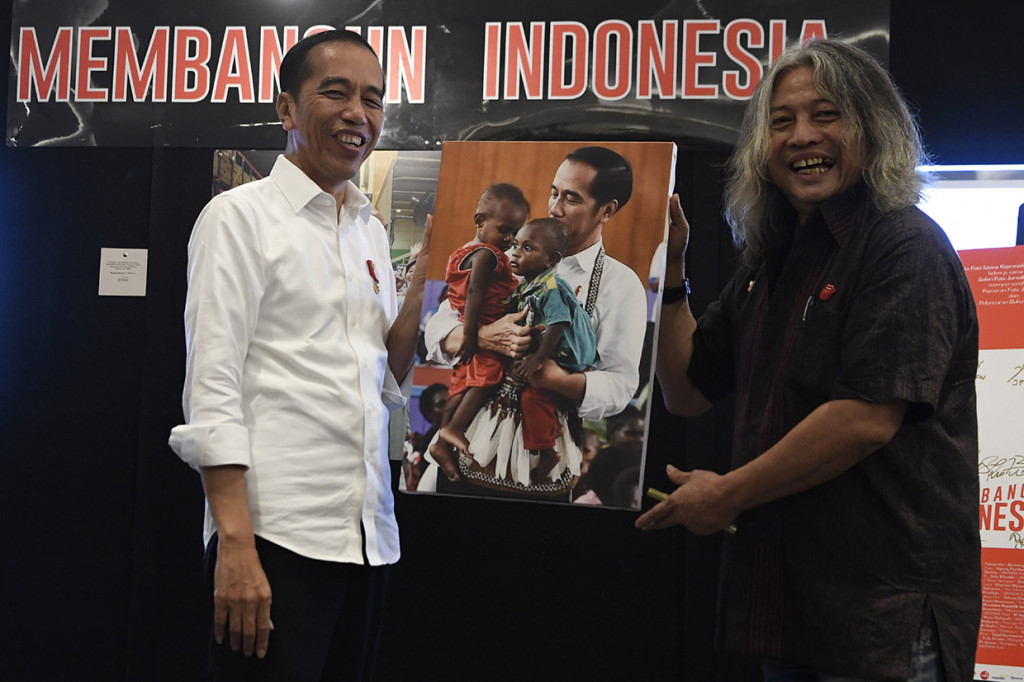 Jokowi mengaku terkesan melihat foto dirinya tengah menggendong anak Papua. Foto ini juga yang diserahkan oleh kurator foto Mpu Ageng Oscar Motuloh sebagai cendera mata untuk Presiden Jokowi.