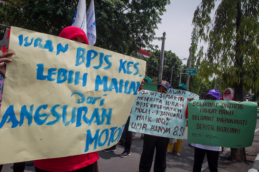 Massa yang tergabung Forum Peduli Buruh membawa poster saat melakukan aksi unjuk rasa menolak kenaikan BPJS di kantor DPRD Sukoharjo, Jawa Tengah.