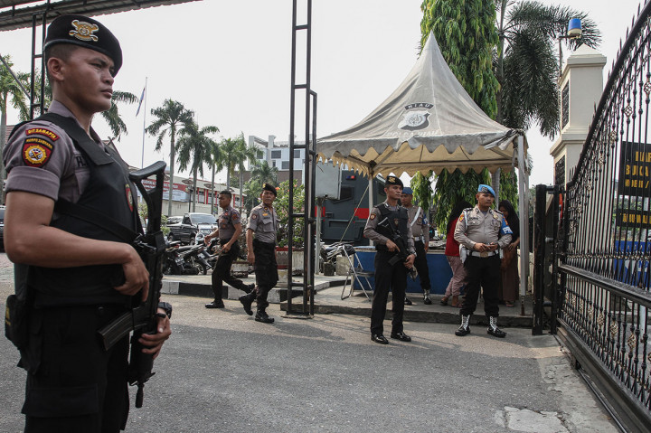Petugas Kepolisian Polda Riau bersenjata lengkap berjaga di depan pintu masuk Mapolda Riau di Pekanbaru. Antara Foto/Rony Muharrman
