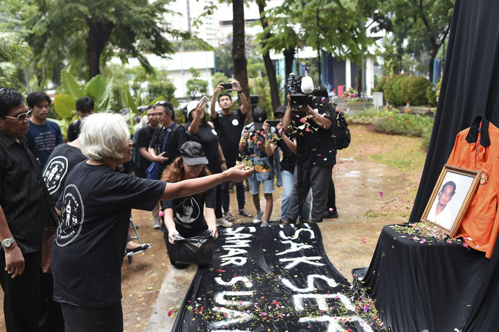 Aktivis Jaringan Solidaritas Korban untuk Keadilan (JSKK) yang juga ibu Bernardinus Realino Norma Irmawan alias Wawan, korban penembakan Tragedi Semanggi I Maria Catarina Sumarsih (kedua kanan) disaksikan suaminya menaburkan bunga saat peringatan 21 tahun tragedi Semanggi I di Universitas Katolik Indonesia Atma Jaya, Jakarta.