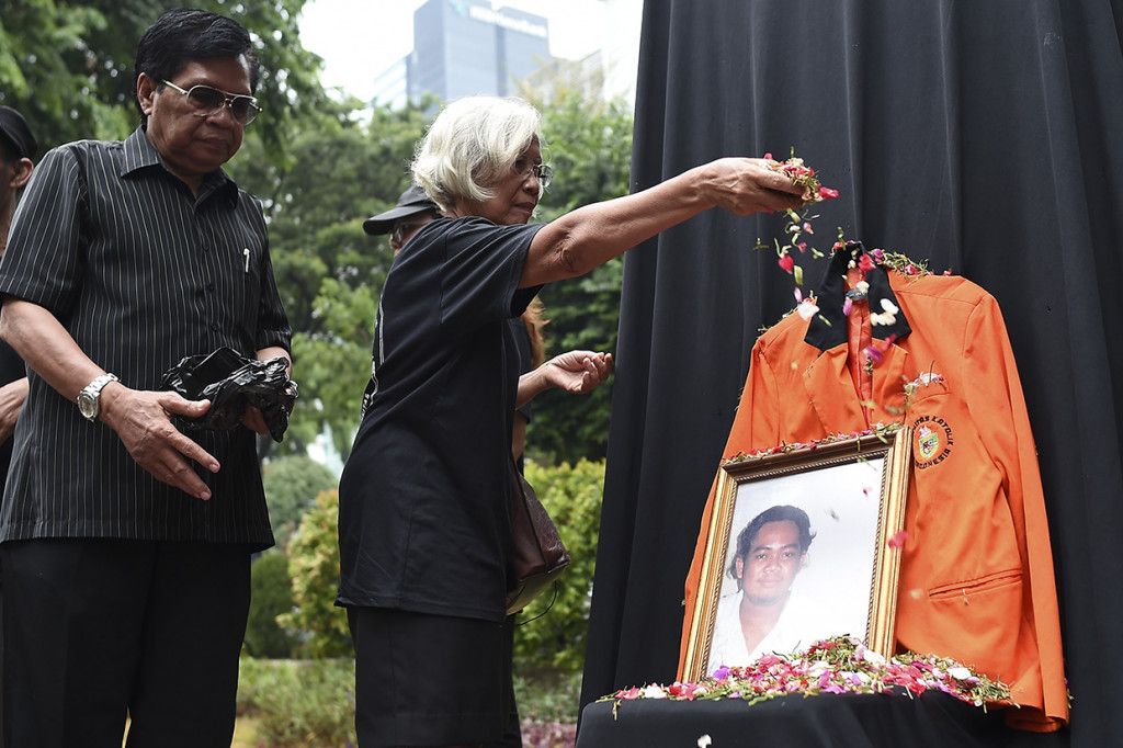 Aktivis Jaringan Solidaritas Korban untuk Keadilan (JSKK) yang juga ibu Bernardinus Realino Norma Irmawan alias Wawan, korban penembakan Tragedi Semanggi I Maria Catarina Sumarsih (kanan) bersama suaminya menaburkan bunga saat peringatan 21 tahun tragedi Semanggi I di Universitas Katolik Indonesia Atma Jaya, Jakarta.