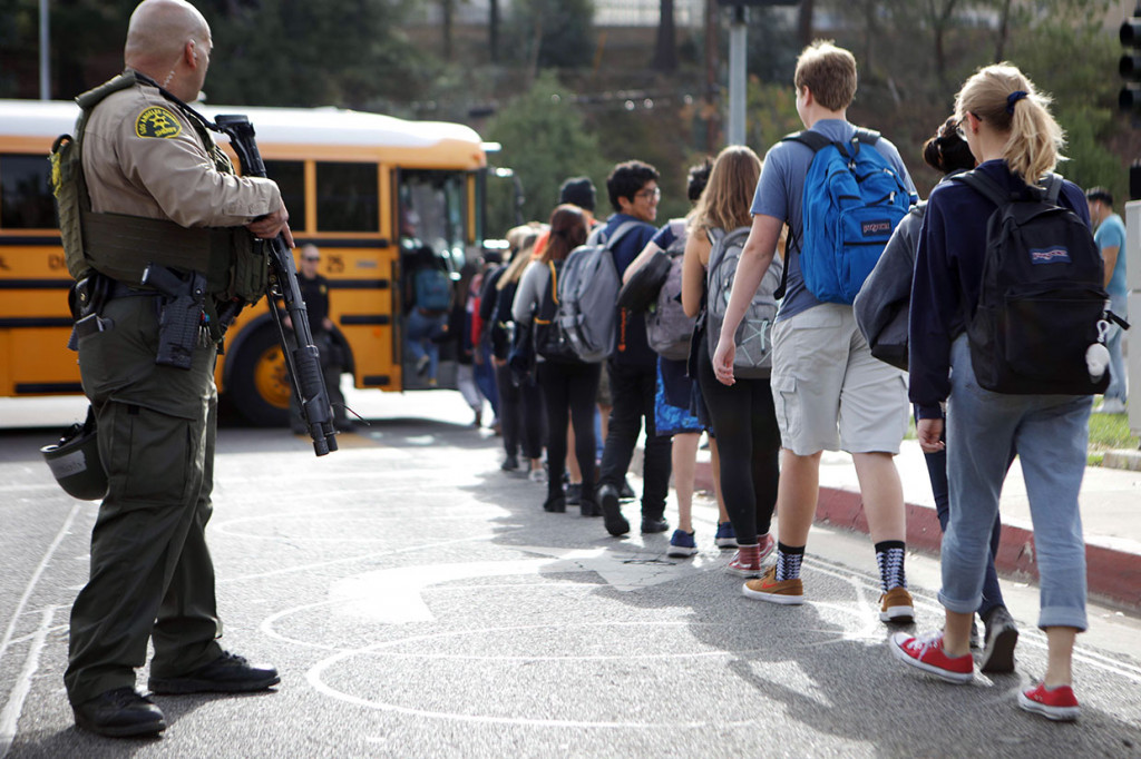 Petugas kepolisian bersenjata lengkap berjaga-jaga saat siswa sebuah SMA di California dipulangkan lebih awal pascaterjadinya penembakan yang menewaskan dua orang, Kamis, 14 November 2019 waktu setempat.