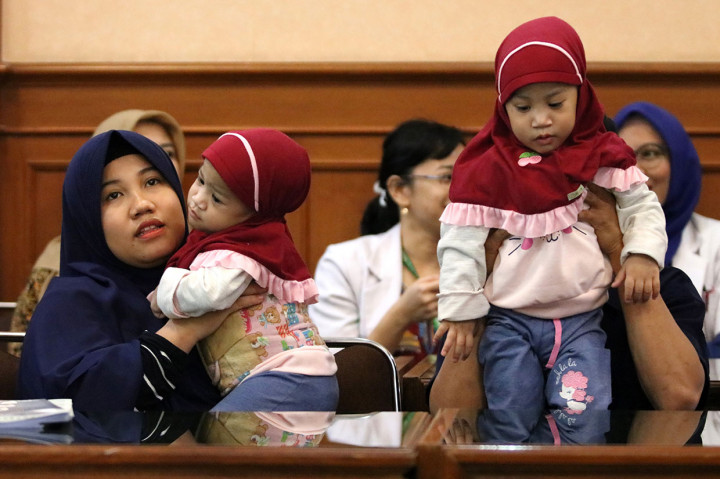 Bayi kembar siam dempet dada dan perut asal Kendari, Sulawesi Tenggara Azila (kiri) digendong ibunya Silvina Dewi dan Aqila digendong bapaknya Jayasri di Rumah Sakit Umum Daerah (RSUD) Dr Soetomo, Surabaya, Jawa Timur, Jumat, 15 November 2019. 