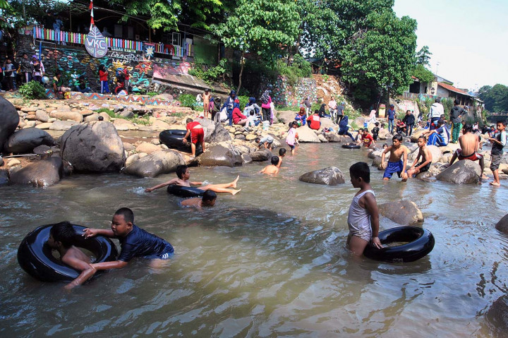 Sejumlah warga dan anak-anak bermain air di area sungai Ciliwung, Kampung Lebak Kantin, Kelurahan Sempur, Kota Bogor, Jawa Barat. 