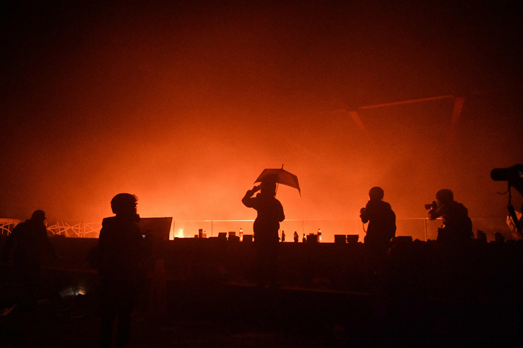 Kobaran api terlihat setelah demonstran anti-pemerintah membakar pintu masuk utama di Polytechnic University, Hong Kong. AFP Photo/Anthony Wallace