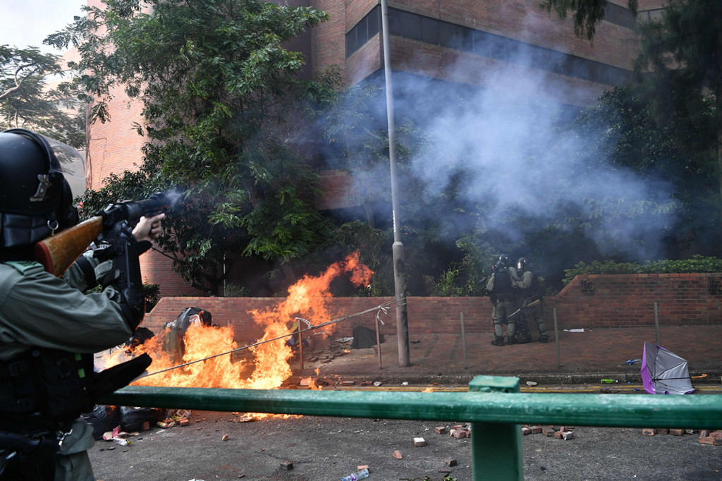 Sekitar 200 pengunjuk rasa tetap berada di Polytechnic University, dan menembakkan panah hingga melempar bom molotov ke aparat yang menggunakan meriam air dan gas air mata. AFP Photo/Anthony Wallace