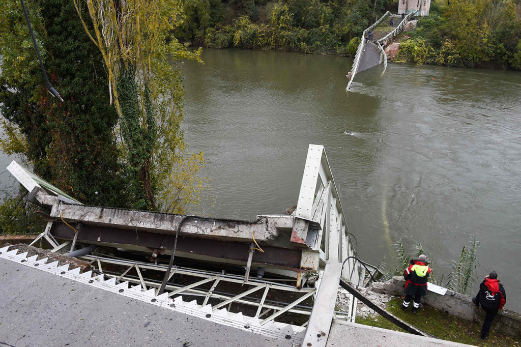 Tim SAR berdiri di samping jembatan gantung yang runtuh di Mirepoix-sur-Tarn, dekat Toulouse, Prancis barat daya, Senin, 18 November 2019 waktu setempat.