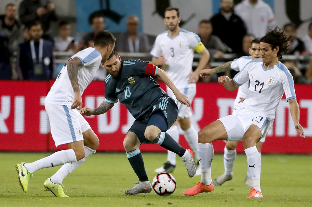 Bintang Argentina Lionel Messi selalu ditempel beberapa pemain Uruguay saat mendapatkan bola.