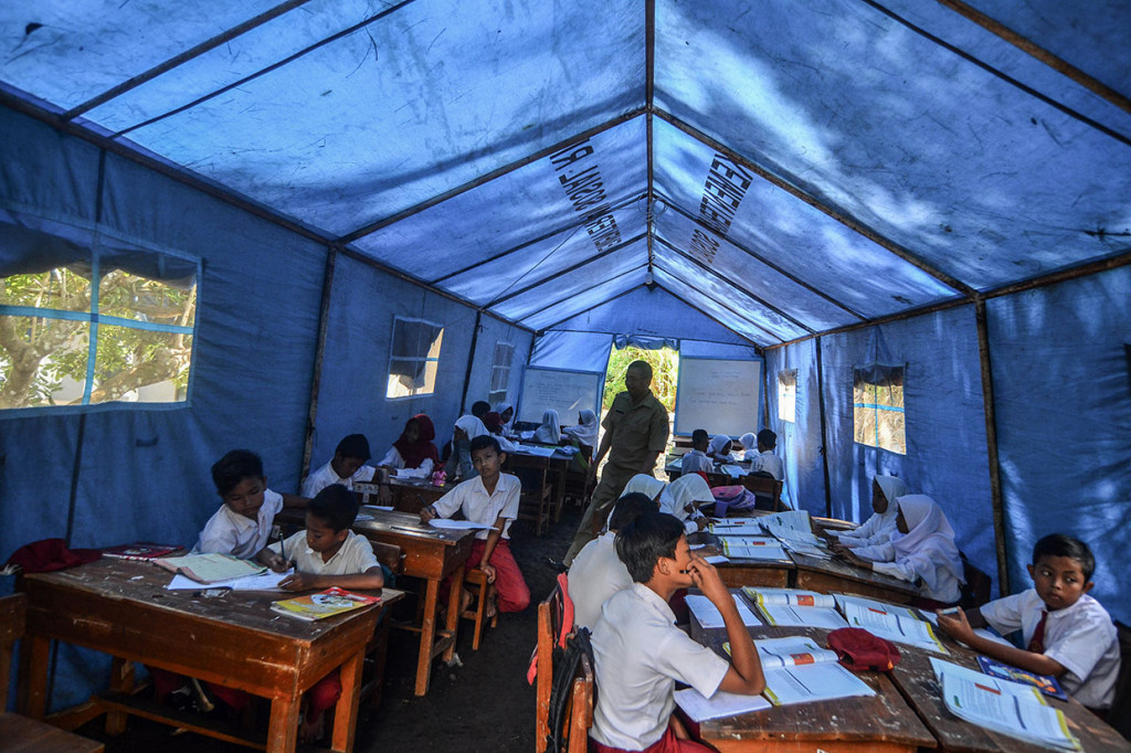 Sejumlah siswa SDN 2 Kadupandak belajar di dalam tenda darurat di Desa Kadupandak, Kecamatan Tambaksari, Kabupaten Ciamis, Jawa Barat, Senin, 18 November 2019. 
