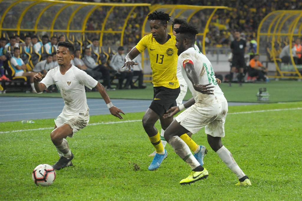Pesepak bola Timnas Indonesia Teuku Muhammad Ichsan (bawah) berebut bola dengan pesepak bola Timnas Malaysia Mohamadou Sumareh (tengah) saat pertandingan kualifikasi Piala Dunia 2022 Grup G Zona Asia di Stadion Bukit Jalil, Kuala Lumpur, Malaysia. Antara Foto/Rafiuddin Abdul Rahman
