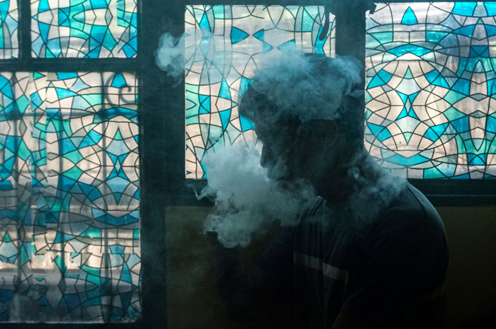 Ilustrasi foto menunjukkan seorang pelanggan merokok di sebuah toko vape di Manila pada Rabu, 20 November 2019. 