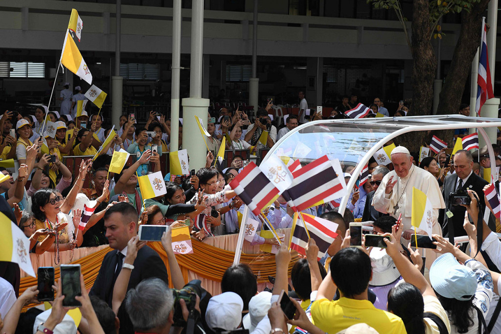 Paus Paus Francis melambaikan tangan kepada orang-orang yang memegang bendera Thailand dan Vatikan ketika ia meninggalkan Rumah Sakit St. Louis di Bangkok melambaikan tangan kepada orang-orang yang memegang bendera Thailand dan Vatikan ketika ia meninggalkan Rumah Sakit St. Louis di Bangkok