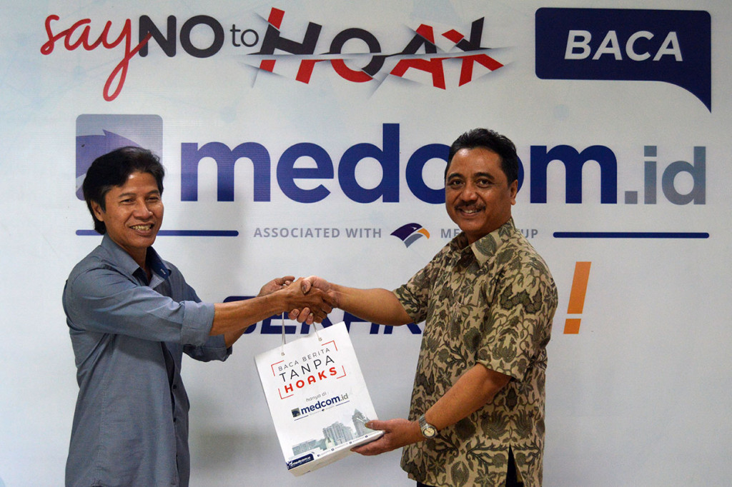 Anggota Kelompok Kerja (Pokja) Komisi Pendataan dan Penelitian Media Dewan Pers Winarto bertukar cendera mata dengan Direktur Pemberitaan Medcom.id Abdul Kohar.