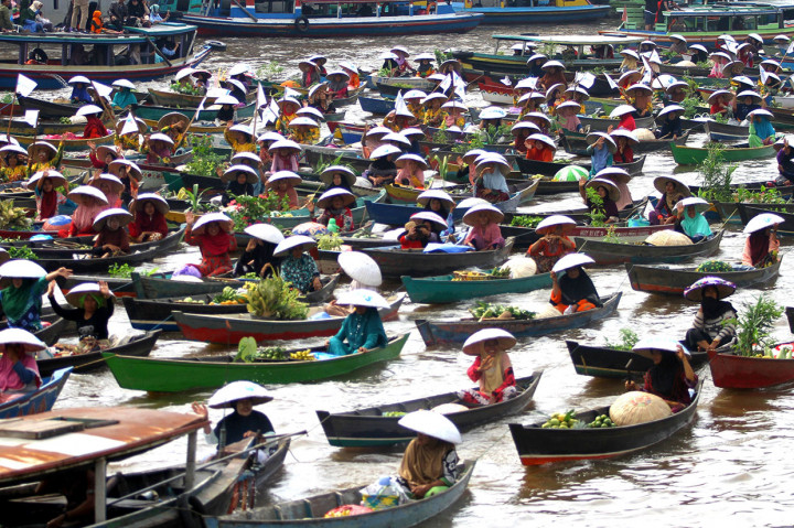 Sejumlah pedagang pasar terapung melakukan atraksi jukung berenteng di sungai Martapura, Banjarmasin, Kalimantan Selatan.