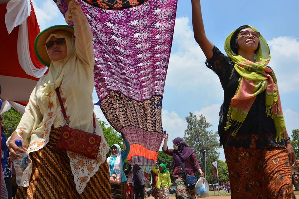 Peserta membentangkan kain batik saat parade 1.000 meter batik di Gelora A Yani Kota Mojokerto, Jawa Timur.
