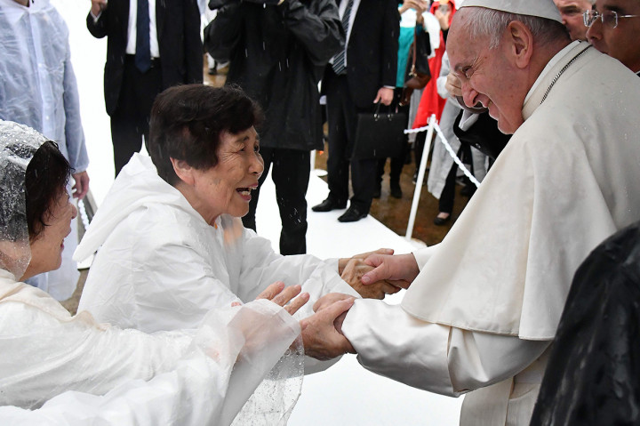 Paus Fransiskus berjabat tangan dengan wanita Jepang saat tiba untuk menyampaikan pidatonya di Nagasaki.