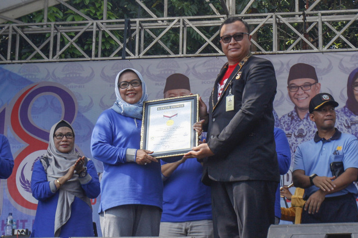 Bupati Bogor Ade Yasin (kiri) menerima tropi penghargaan Museum Rekor Dunia Indonesia (MURI) dari Wakil Direktur MURI Osman Semesta Soesilo (kanan) dalam pemecahan sajian nasi liwet terbanyak di LIPI Cibinong, Bogor, Jawa Barat.