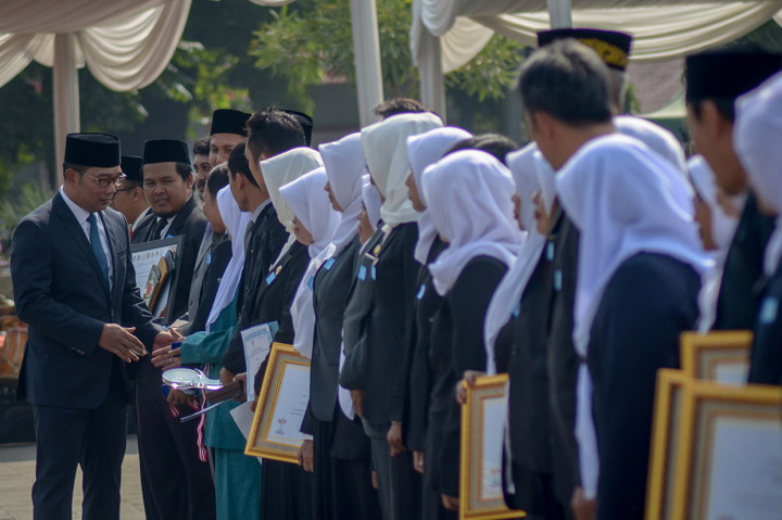 Gubernur Jawa Barat, Ridwan Kamil memberikan penghargaan kepada perwakilan guru terbaik saat upacara peringatan Hari Guru Nasional di Lapangan Gasibu, Bandung, Jawa Barat. Pada momentum peringatan Hari Guru Nasional tahun ini, Ridwan Kamil berjanji siswa-siswi yang belajar di Jabar tidak lagi harus membayar uang iuran sekolah (SPP) pada 2020. Antara Foto/Raisan Al Farisi