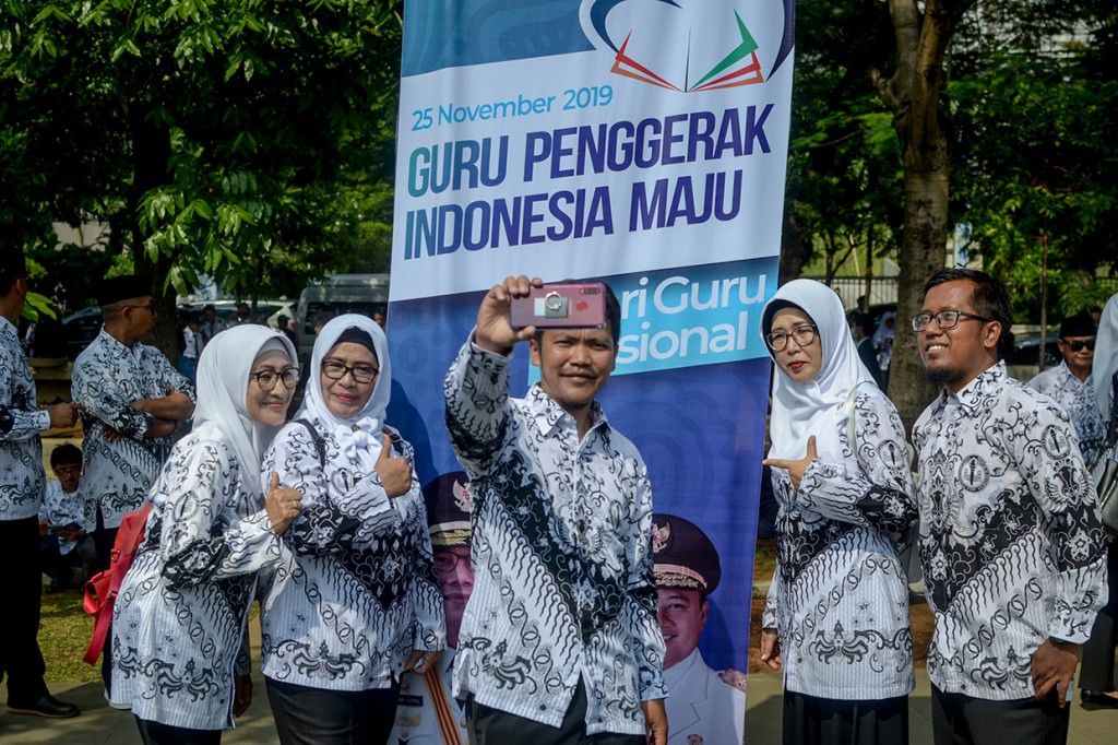 Sejumlah guru berswafoto usai mengikuti upacara dalam rangka peringatan Hari Guru Nasional yang di pimpin oleh Gubernur Jawa Barat, Ridwan Kamil di Lapangan Gasibu, Bandung, Jawa Barat. Antara Foto/Raisan Al Farisi