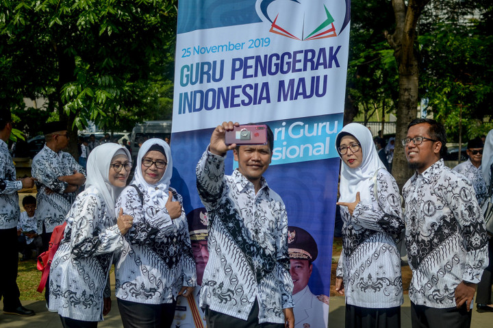 Sejumlah guru berswafoto usai mengikuti upacara dalam rangka peringatan Hari Guru Nasional yang di pimpin oleh Gubernur Jawa Barat, Ridwan Kamil di Lapangan Gasibu, Bandung, Jawa Barat. Antara Foto/Raisan Al Farisi