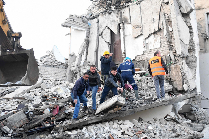 Pekerja membersihkan reruntuhan gedung yang ambruk akibat gempa di Albania.