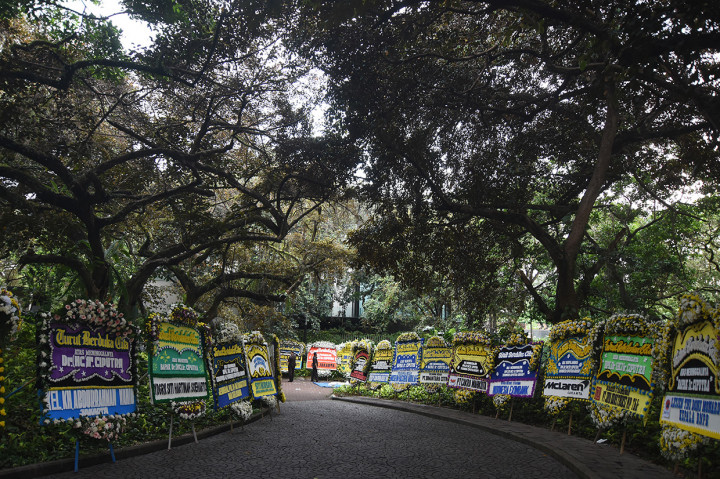 Petugas keamanan berjaga diantara karangan bunga ucapan belasungkawa di halaman kediaman almarhum Ciputra di Jalan Bukit Golf Utama, Jakarta. Pengusaha dan pendiri Ciputra Group tersebut meninggal dunia di Rumah Sakit Gleneagles, Singapura pada Rabu, 27 November 2019, dinihari waktu setempat. 