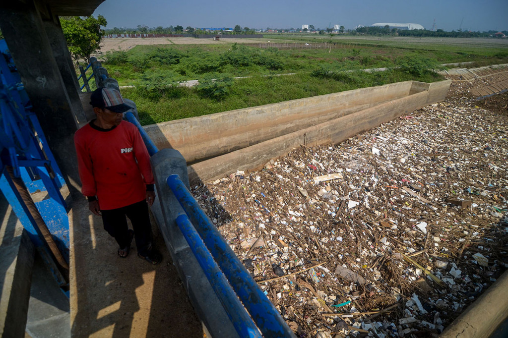Warga melihat tumpukan sampah yang menutupi permukaan Sungai Cikeruh yang bermuara ke Sungai Citarum di Sukarame, Cileunyi, Kabupaten Bandung, Jawa Barat, Kamis, 28 November 2019.