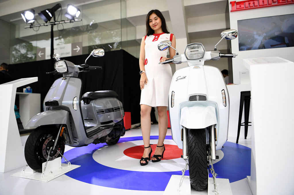 Model berpose di dekat motor Lambretta V200 Special saat pemeran IIMS Motobike Expo 2019 di Istora Senayan, Jakarta, Jumat, 29 November 2019. 

