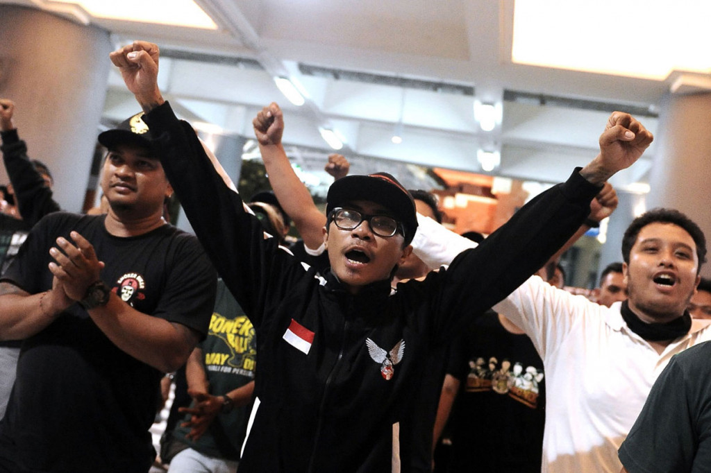 Suporter sepak bola Indonesia Andreas Setiawan (tengah) disambut rekan-rekannya setibanya di Bandara Internasional I Gusti Ngurah Rai, Bali, Jumat, 29 November 2019. 