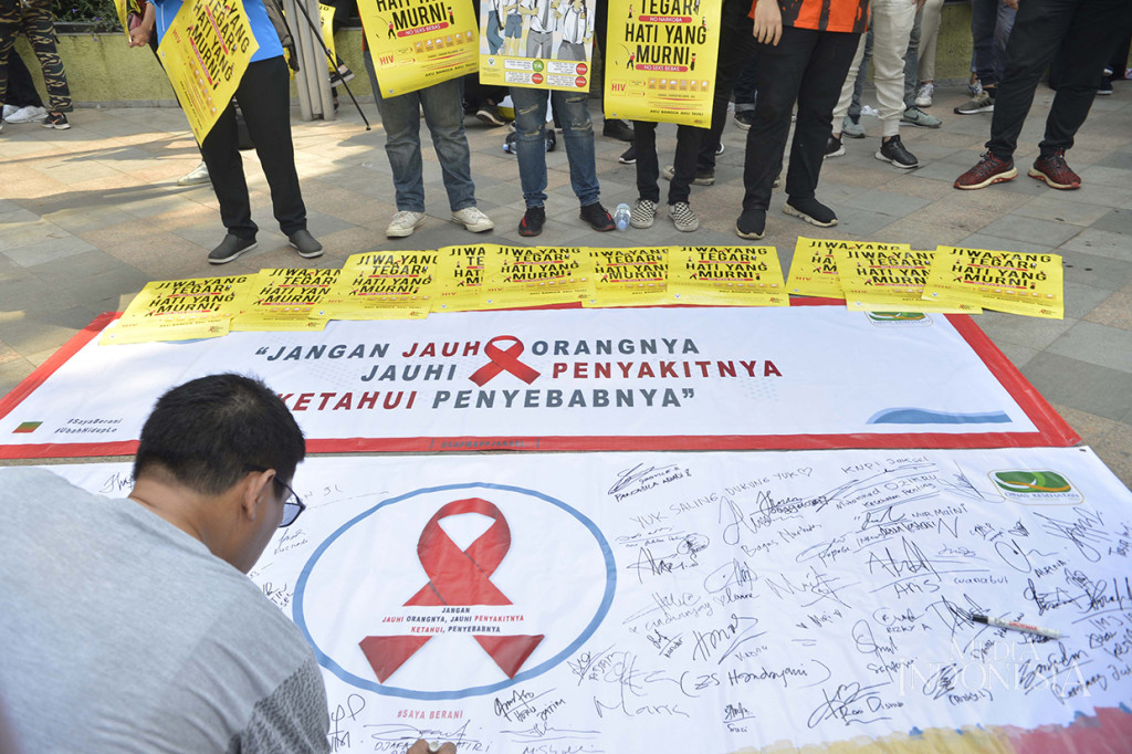 Masyarakat menanda tangani Baliho memperingati hari AIDS Sedunia di arena Car Free Day (CFD) Bundaran HI, Jakarta Pusat. MI/M Irfan