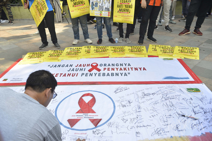 Masyarakat menanda tangani Baliho memperingati hari AIDS Sedunia di arena Car Free Day (CFD) Bundaran HI, Jakarta Pusat. MI/M Irfan