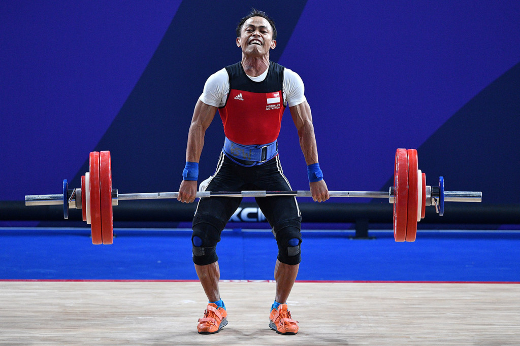 Lifter putra Indonesia Surahmat Wijoyo melakukan angkatan dalam final angkat besi 55 Kg putra SEA Games 2019 di kompleks Olahraga Rizal Memorial, Manila, Filipina.