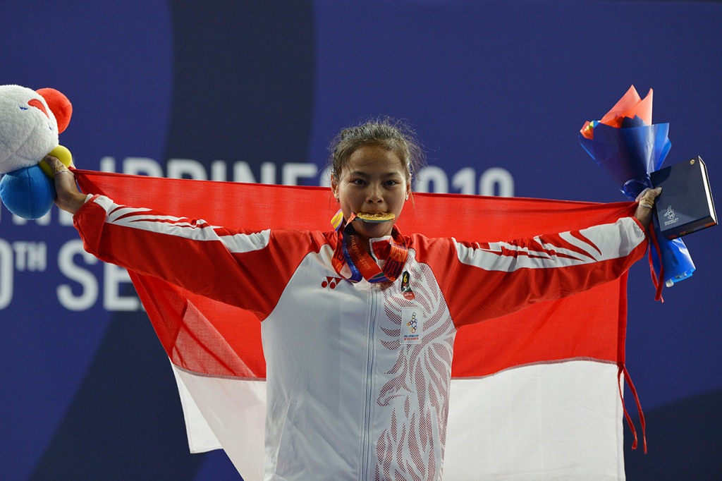 Atlet angkat besi Indonesia Windy Cantika Aisah (menggigit medali seusai upacara penganugerahan medali pertandingan Angkat Besi 49Kg Wanita SEA Games ke-30 di Stadion RSMC Nino Aquino, Manila, Filipina.