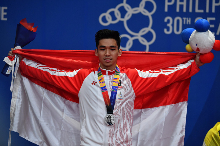 Atlet wushu putra Indonesia Harris Horatius membentangkan bendera Merah-Putih saat penyerahan medali nomor taolu nandao/nangun combine putra SEA Games 2019 di World Trade Center, Manila, Filipina.