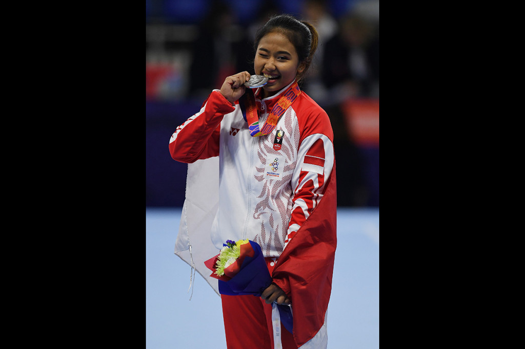 Pesenam Indonesia Irfanaluthfi Rifda menggigit medali peraknya usai penganugerahan medali Senam Artistik SEA Games ke-30 di Rizal Coliseum Stadion RSMC Nino Aquino, Manila.
