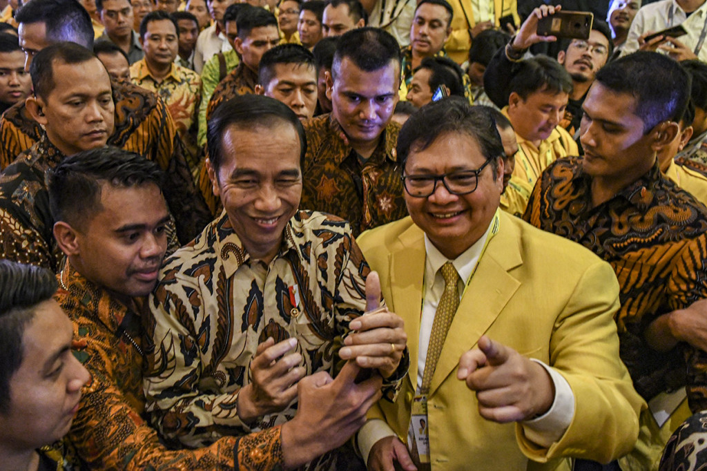 Presiden Joko Widodo didampingi Ketua Umum Partai Golkar Airlangga Hartarto meninggalkan ruangan usai membuka secara resmi Musyawarah Nasional (Munas) Partai Golkar di Jakarta.