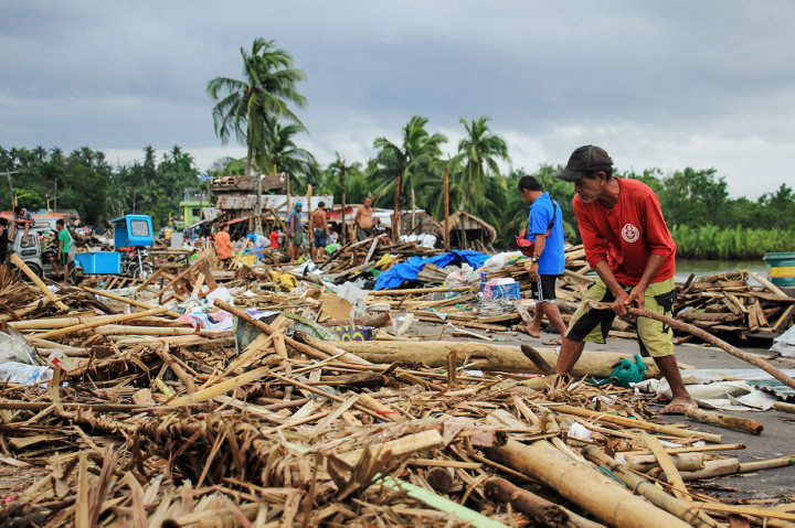 Warga mengumpulkan puing-puing dari rumah mereka yang hancur setelah topan Kammuri menghantam Kota Sorsogon, selatan Manila, Selasa, 3 Desember 2019.