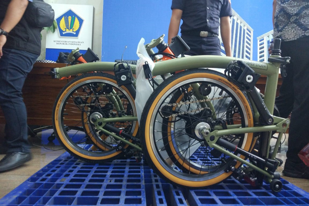 Sementara itu dua sepeda Brompton berwarna hijau lengkap dengan tasnya.