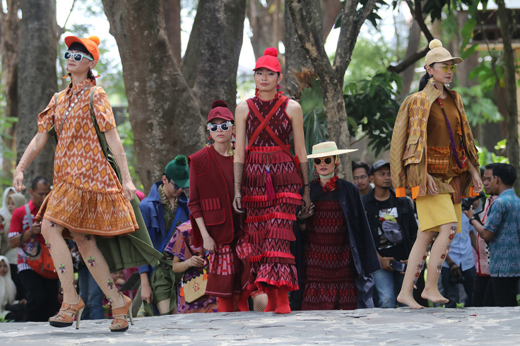 Model memperagakan busana berbahan kain tenun ikat khas Kediri pada Dhoho Street Fashion di Taman Hutan Joyoboyo, Kota Kediri.