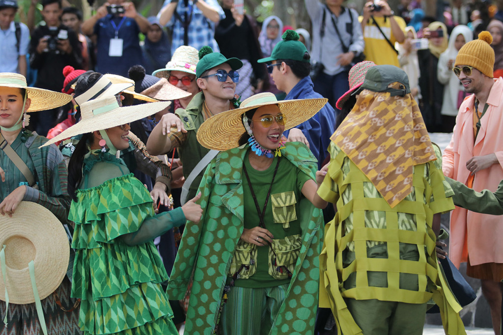 Sejumlah model menari saat memperagakan busana berbahan kain tenun ikat khas Kediri pada Dhoho Street Fashion di Taman Hutan Joyoboyo, Kota Kediri, Jawa Timur.
